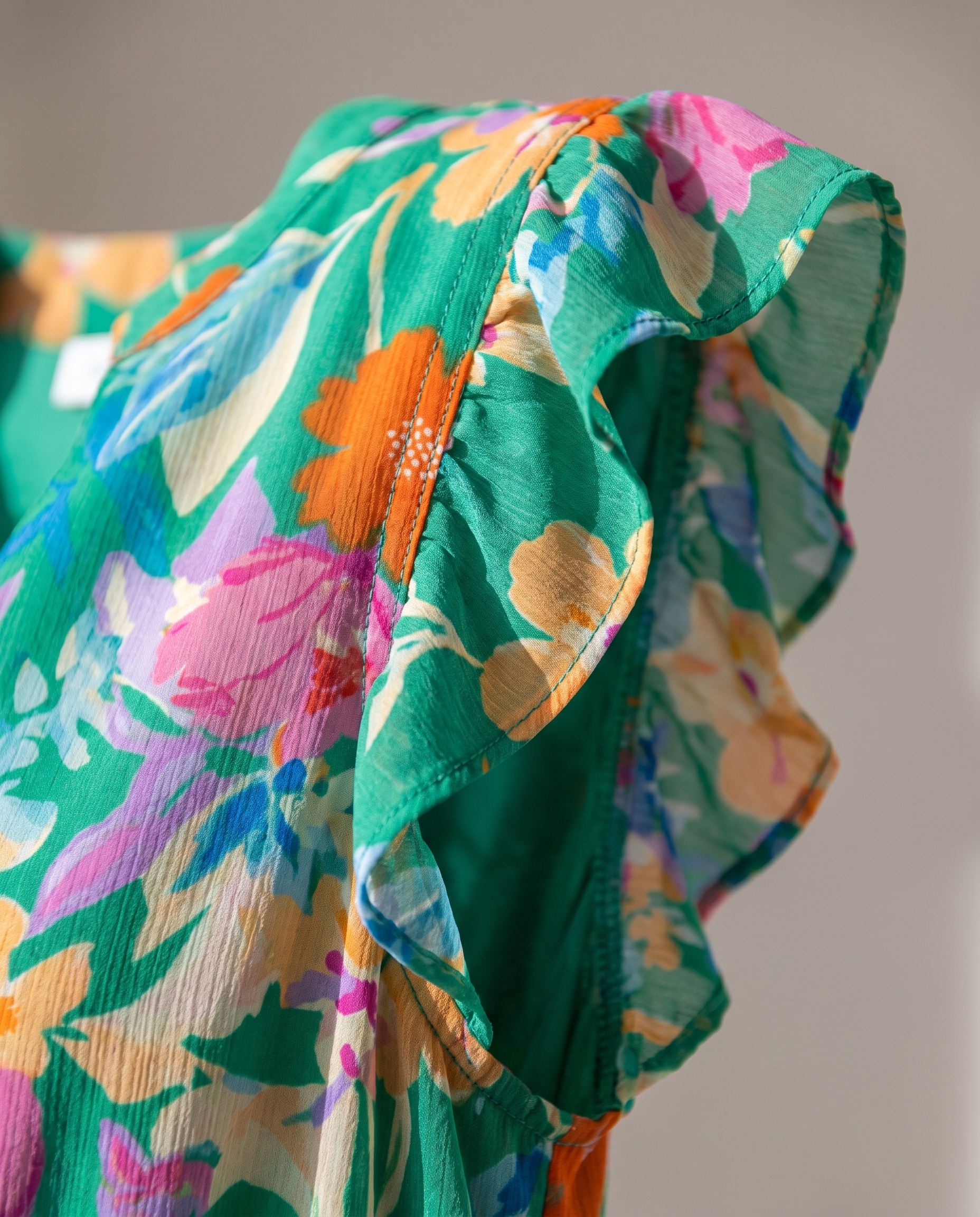 Lila floral tiered midi dress close-up detail of V-neckline and flutter sleeve