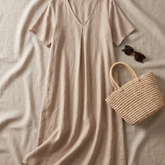 Wrenley maxi in beige styled as a flat-lay with straw bag