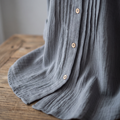Close-up of the Abigail grey pleated blouse fabric, front pleat and buttons